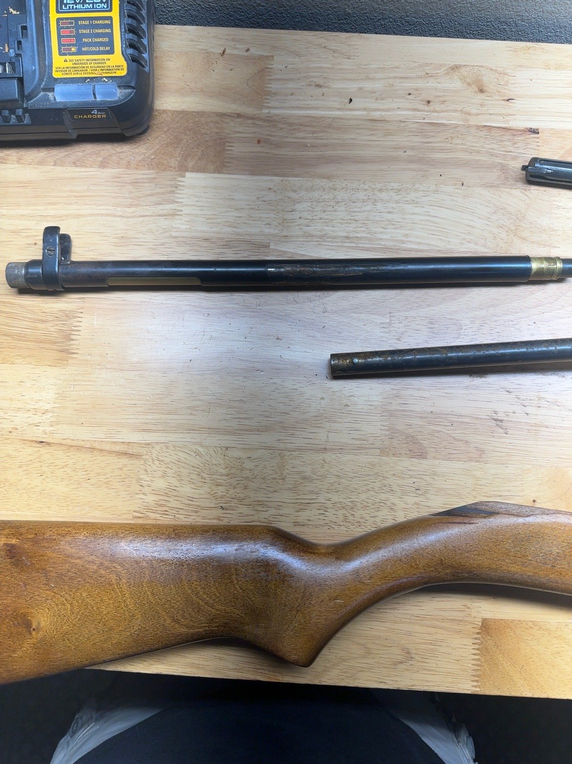 Shotgun magazine tube and wooden stock on workbench