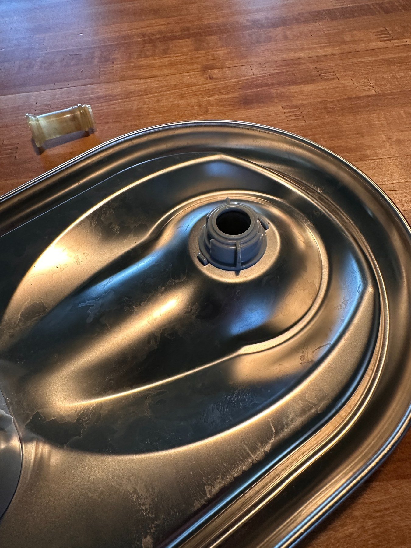 Gray dispenser assembly locked beneath the stainless-steel tray