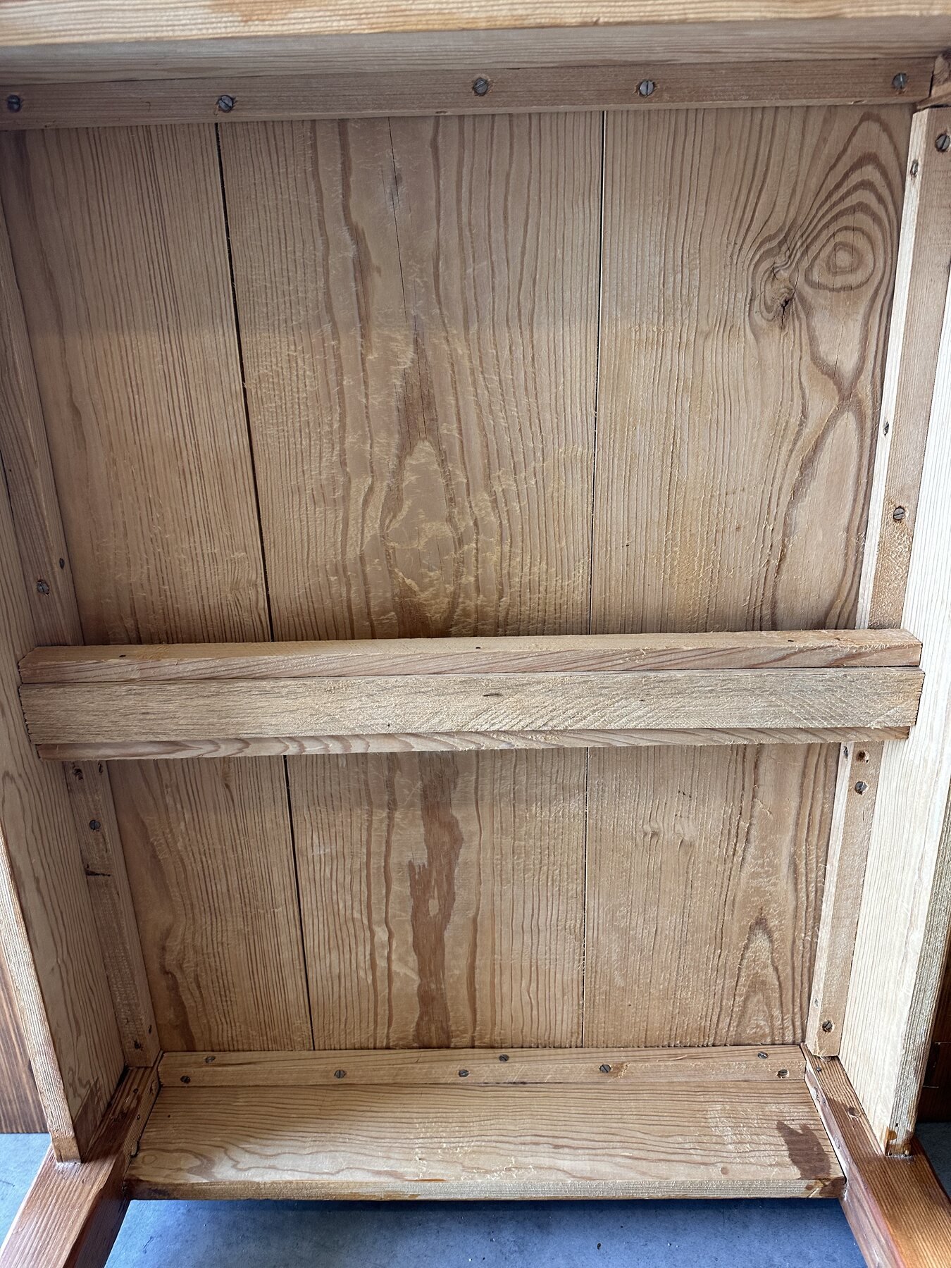 Broad view of unfinished boards, battens, screws, and grain beneath the tabletop