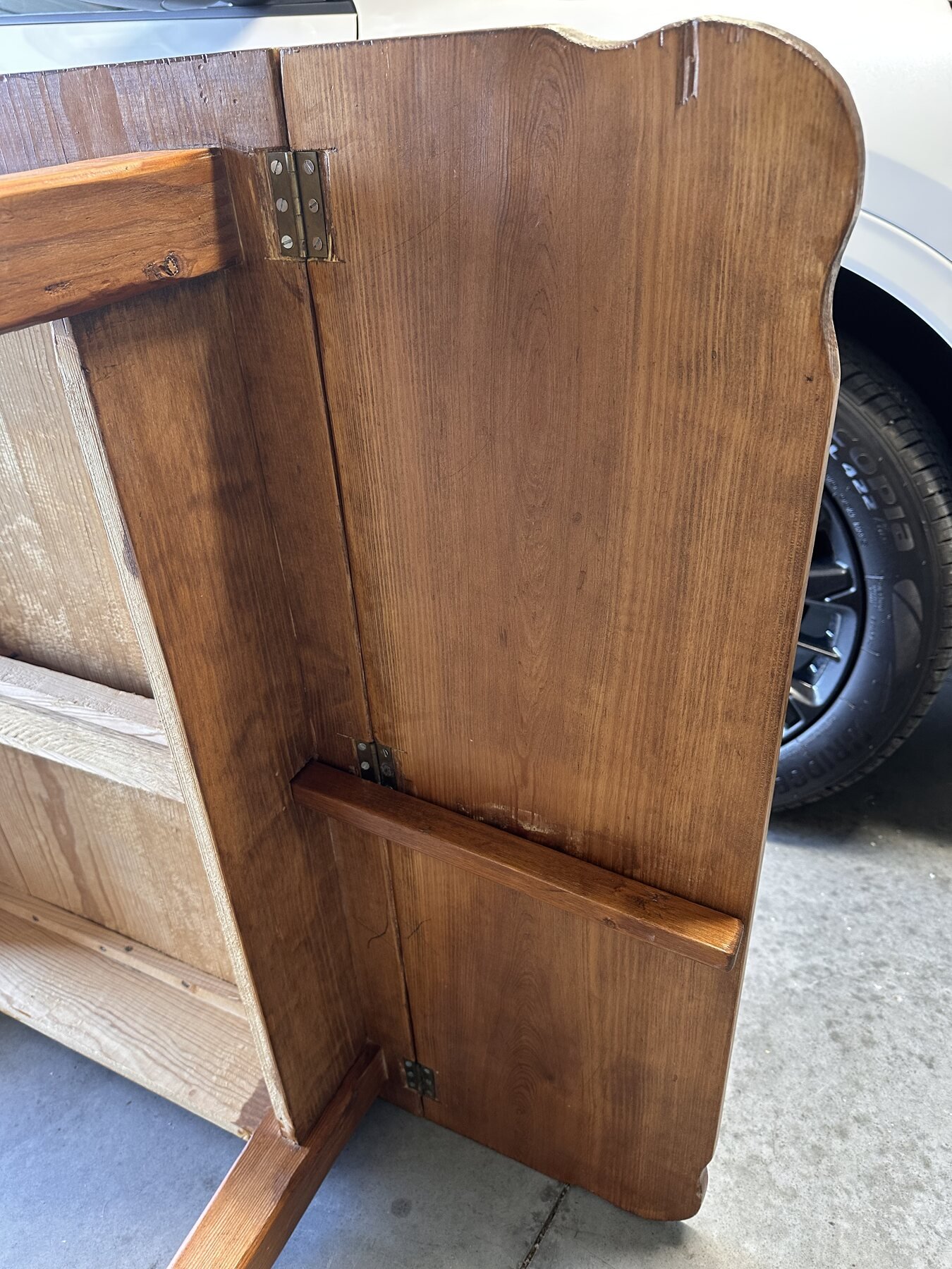 Folded drop leaf and support arm viewed from the side beneath the table