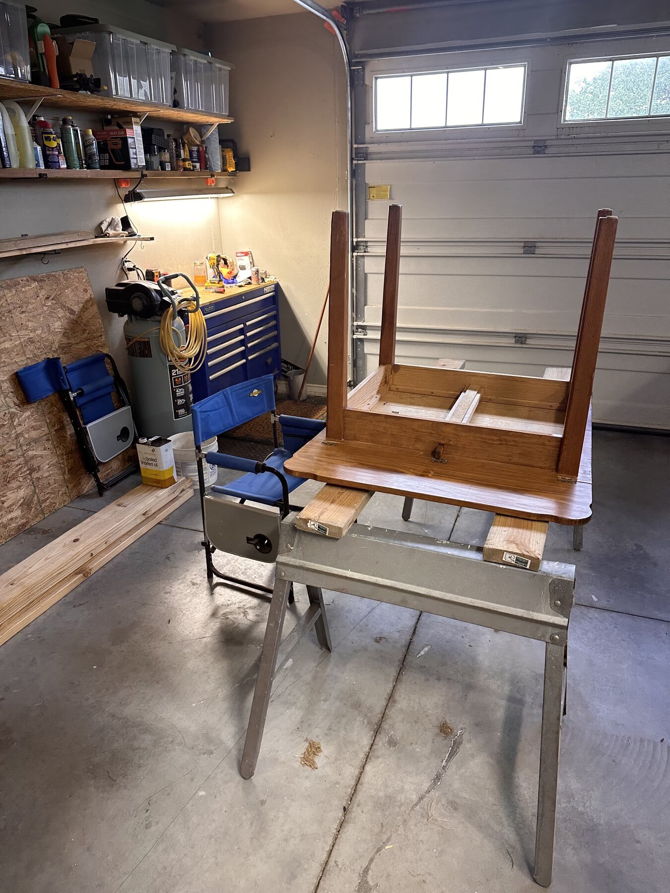 Wide view of the upside-down table on a workbench after the base screws were removed