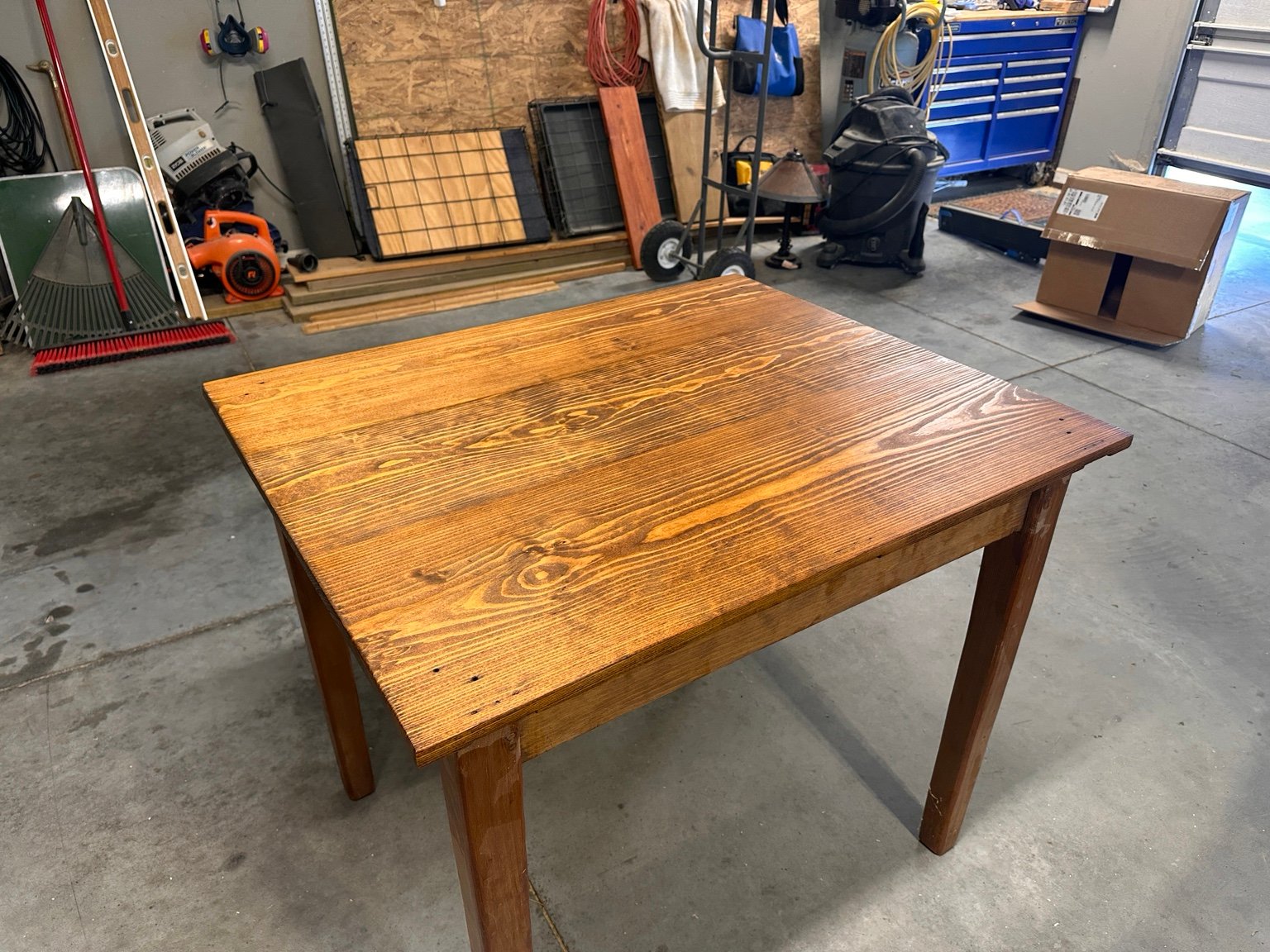Wide workshop view of the drop-leaf table after its third polyurethane coat