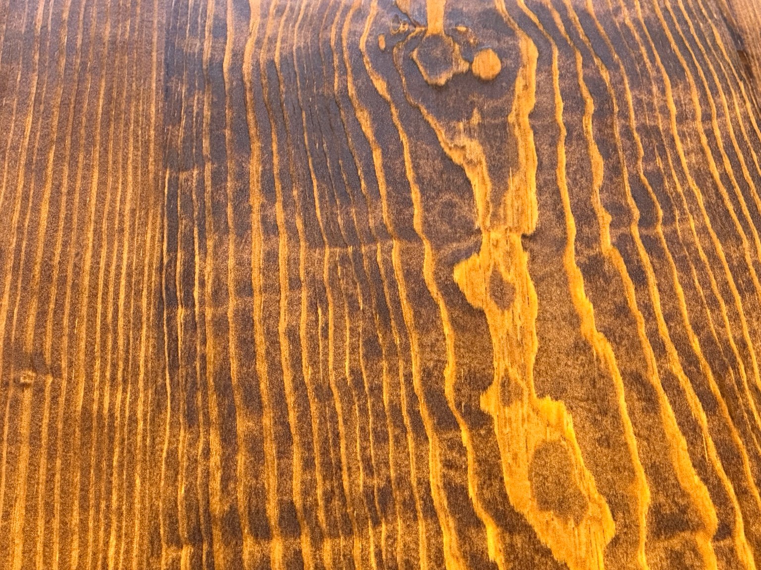Extreme close-up of the center knot and surrounding grain beneath polyurethane layer four