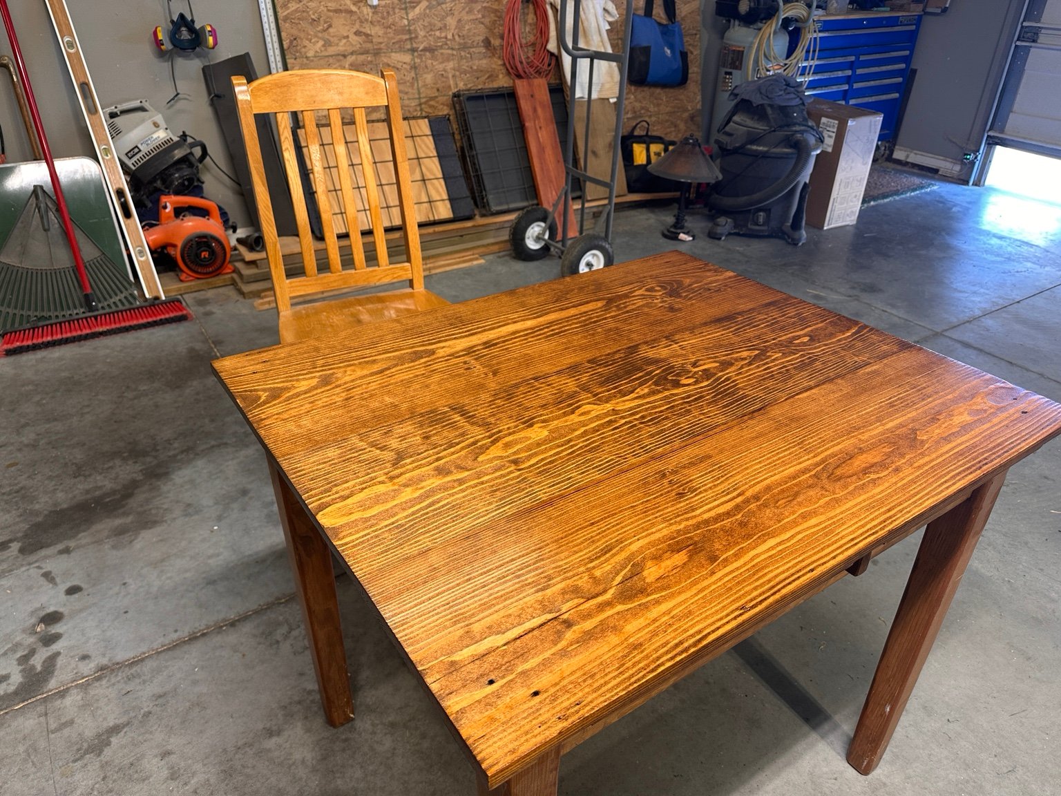 Left-front diagonal view of the table with one wooden chair after coat four