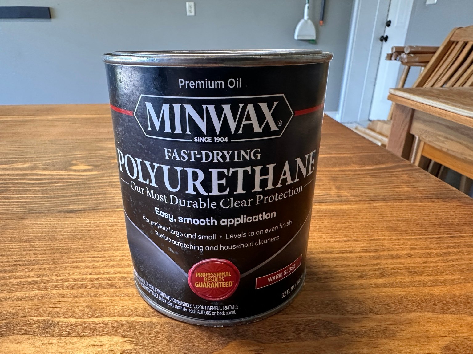 Can of Minwax Fast-Drying Polyurethane marked Warm Gloss on the stained tabletop