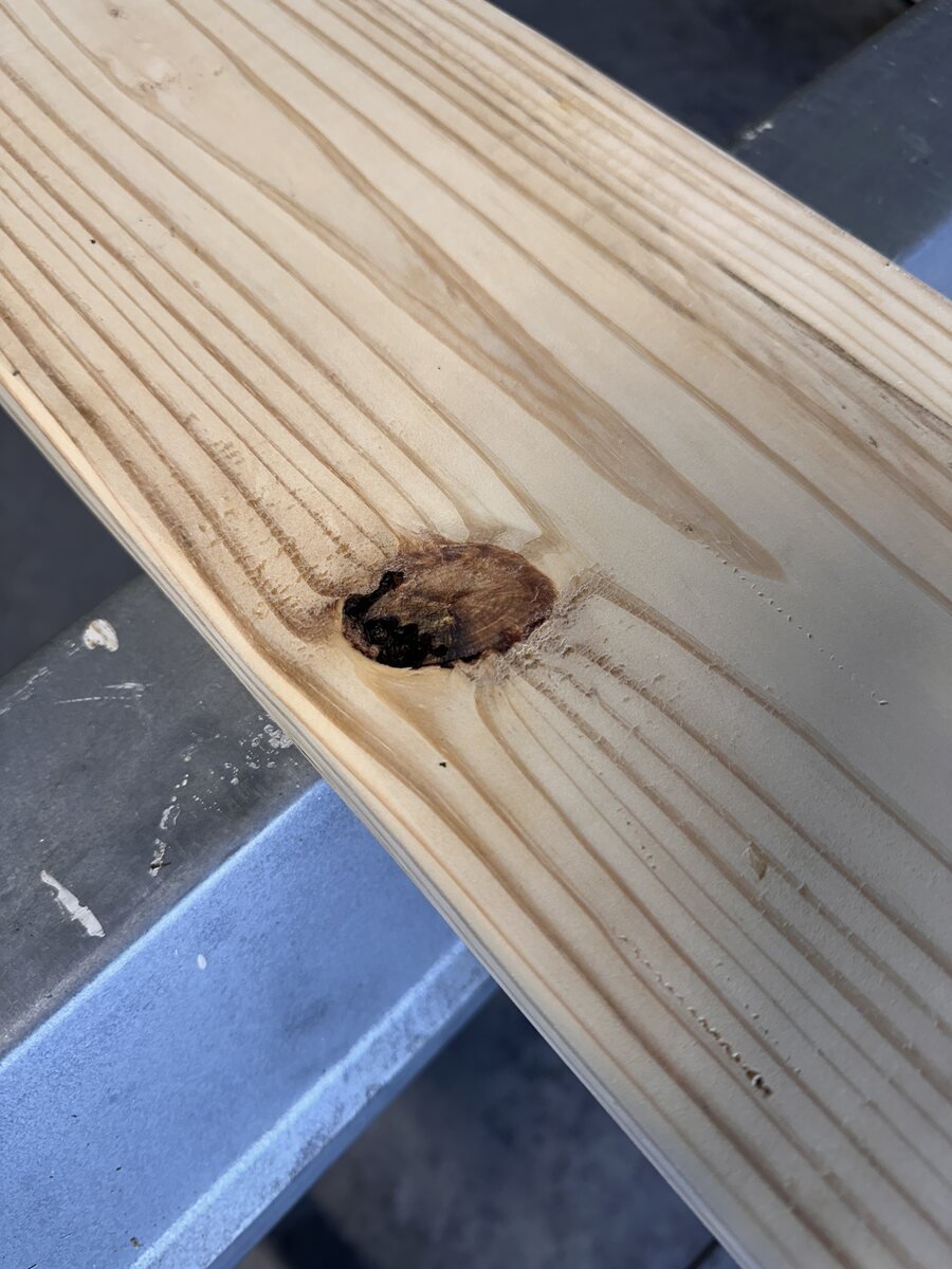 Knot close to the edge of the pine board