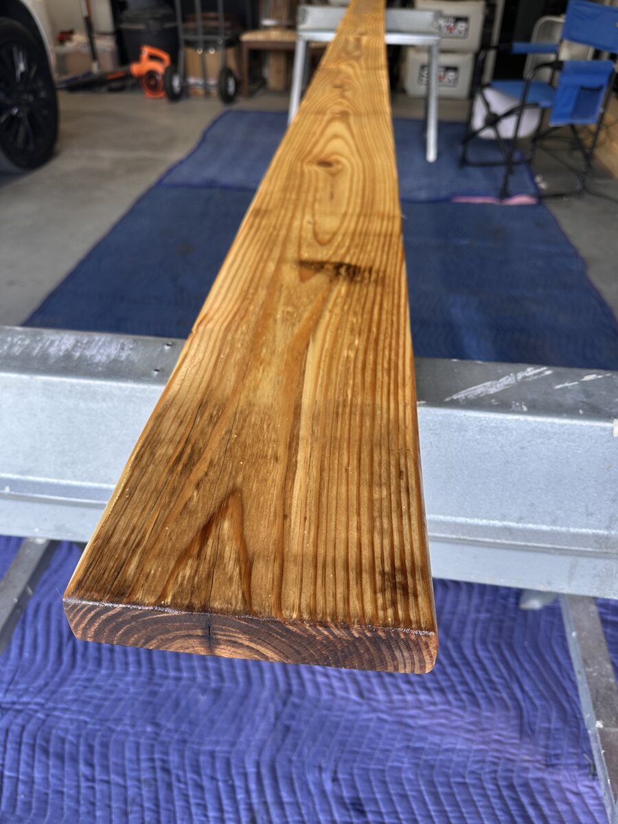 Pine board glowing warmly after its first coat