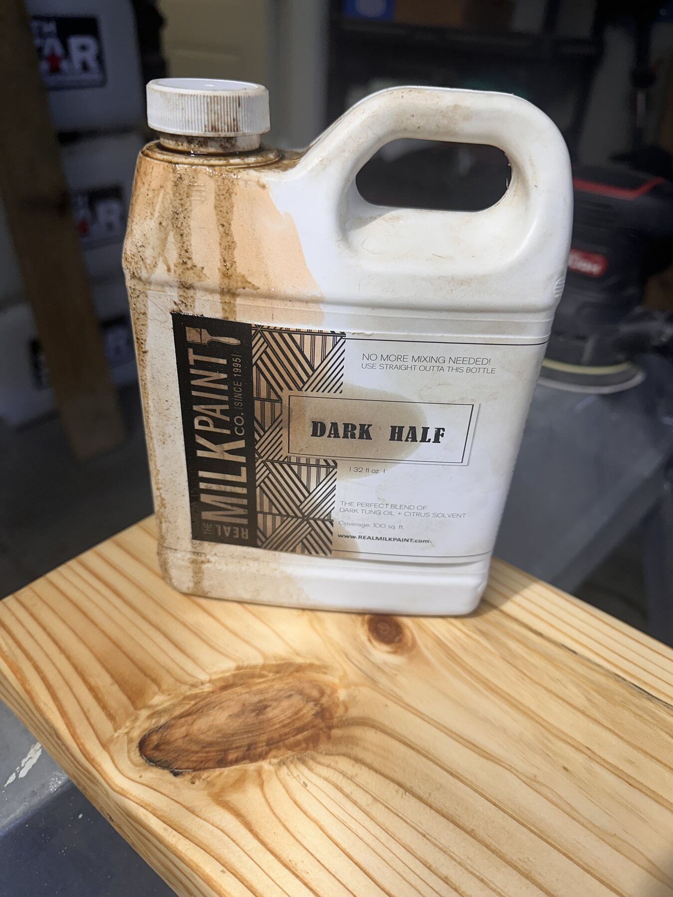 Bottle of Real Milk Paint Dark Half sitting on the finished pine board