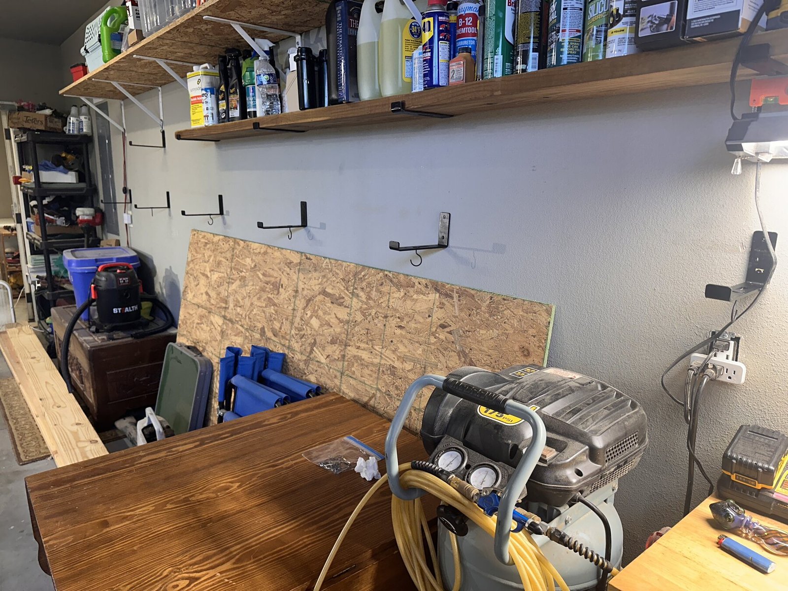Garage wall with black shelf brackets ready below existing shelves