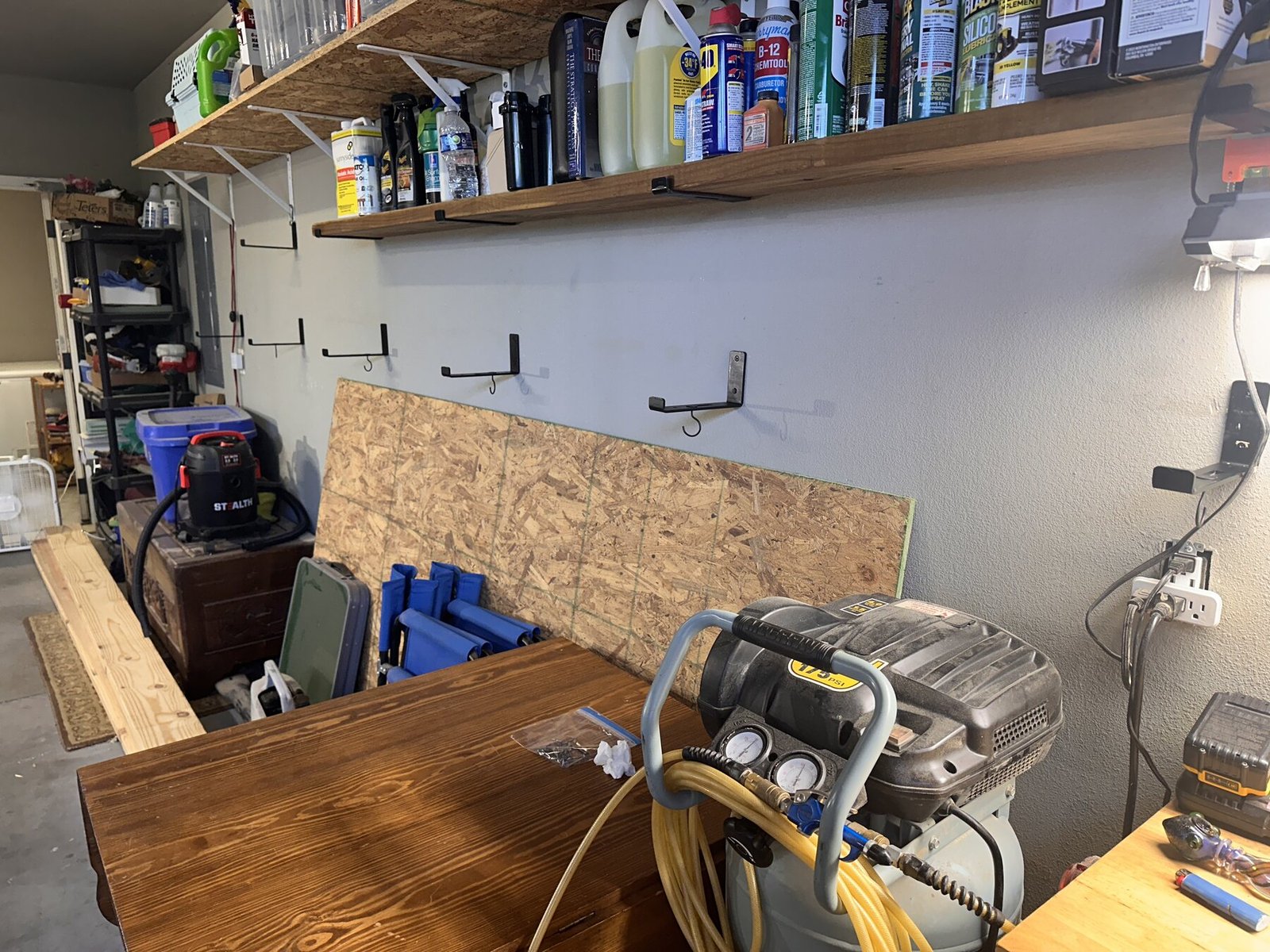 Garage wall showing new brackets below existing shelves