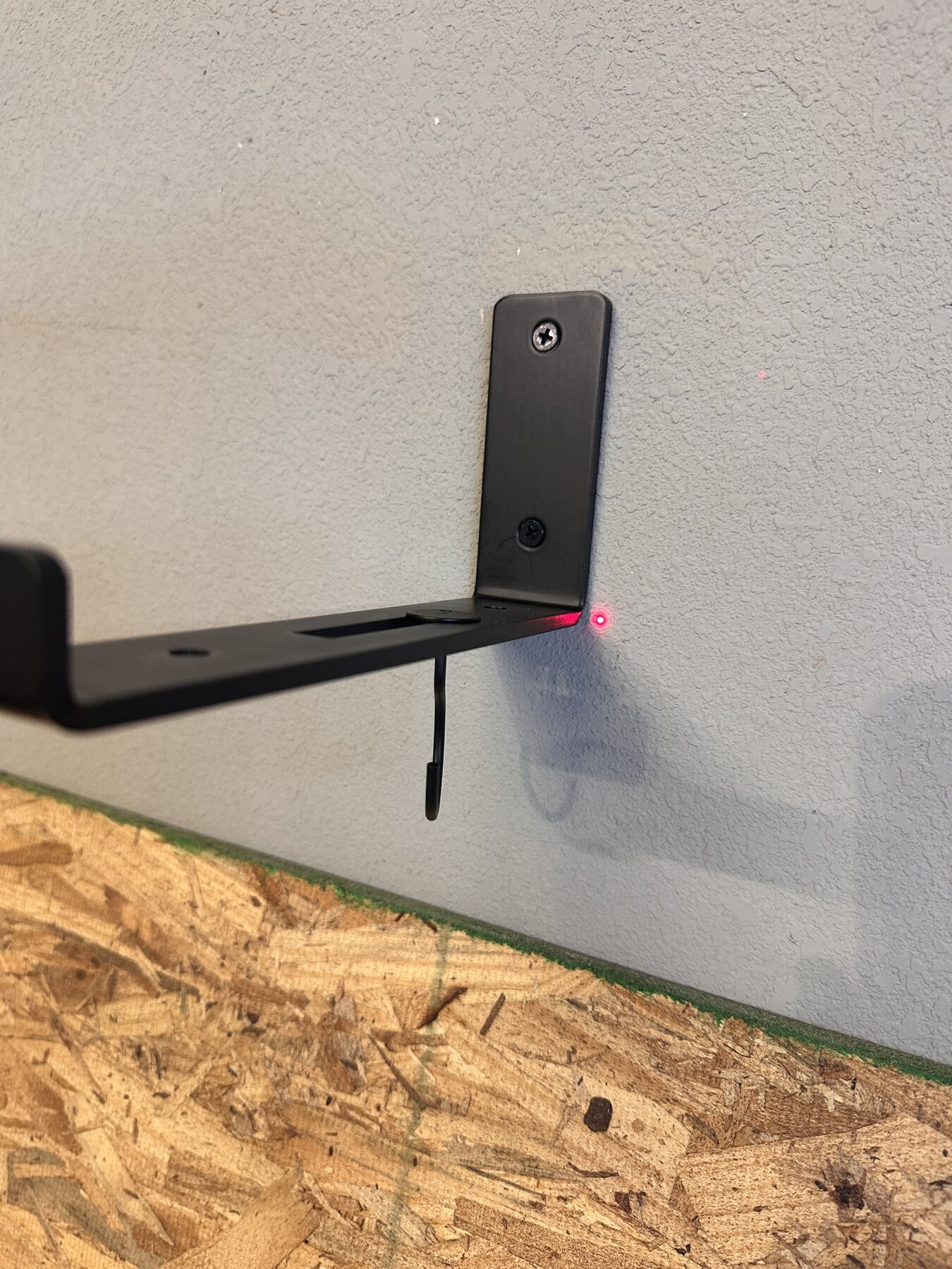 Laser level dot beside a black shelf bracket