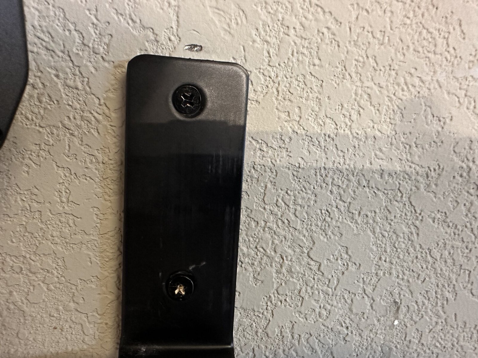 Close-up of shelf bracket screws in wall