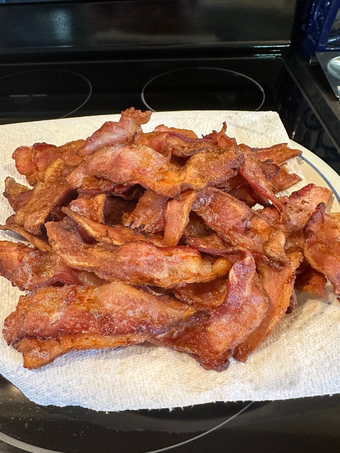 A large pile of crisp bacon draining on paper towels