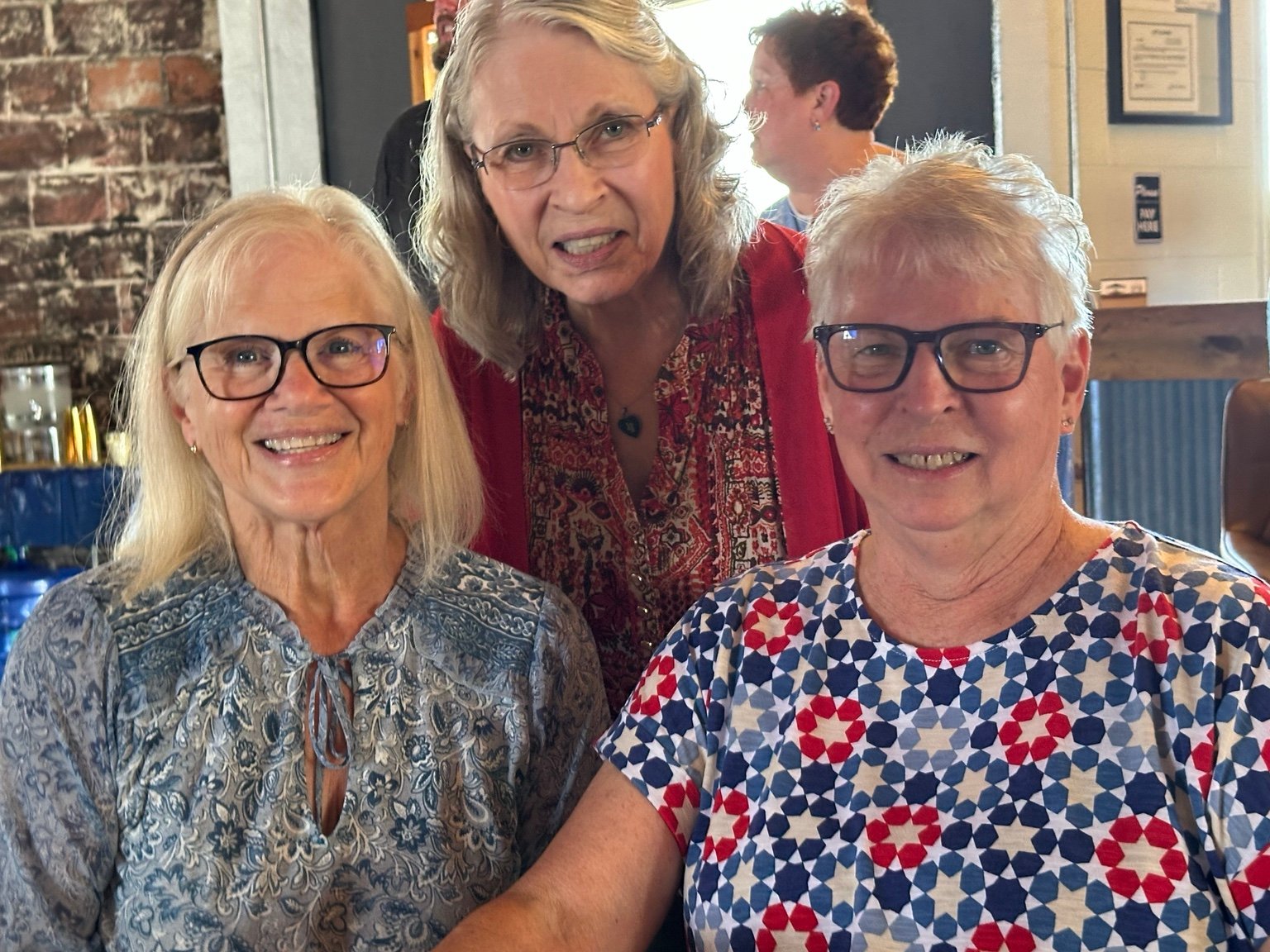 Janet smiling with her friends Becky and Ros at the anniversary party