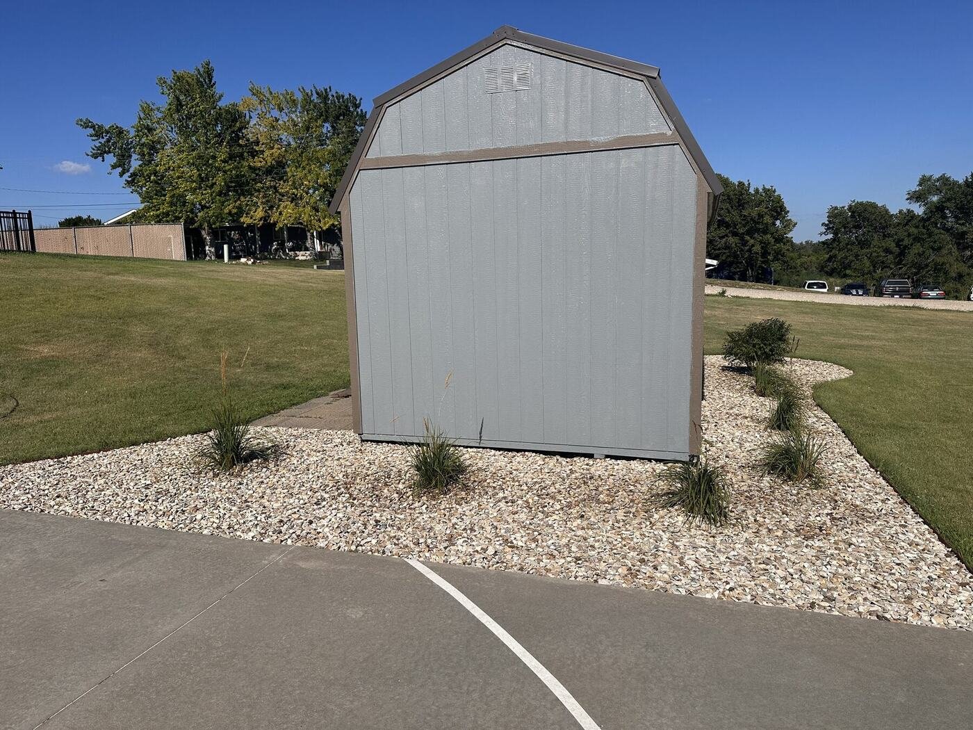 Straight-on view of the shed end and six grasses