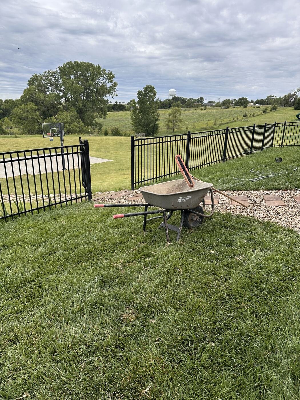 Wheelbarrow and landscaping tools beside the newly completed rock path