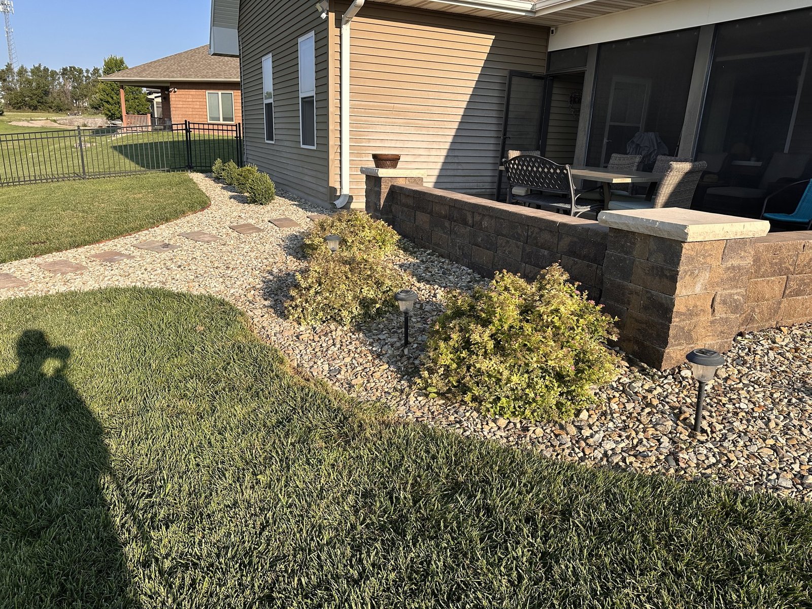 Spirea bushes beside the curved backyard path and screened porch