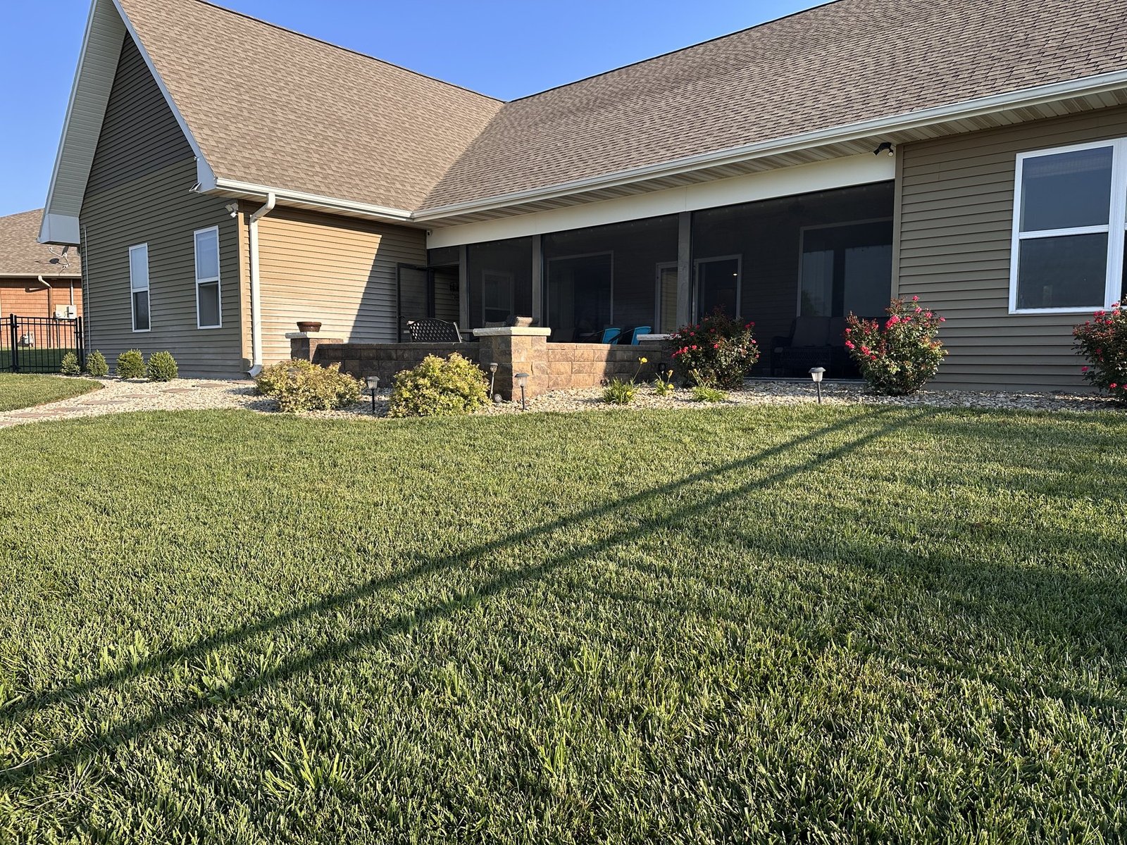 Wide morning view across the lawn toward the landscaped back of the house